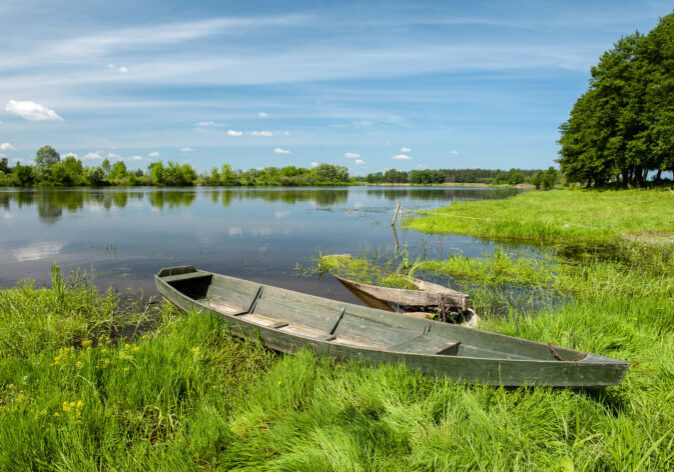 Kleines Holzboot an einem Seeufer in der Masurischen Seenplatte in Polen.