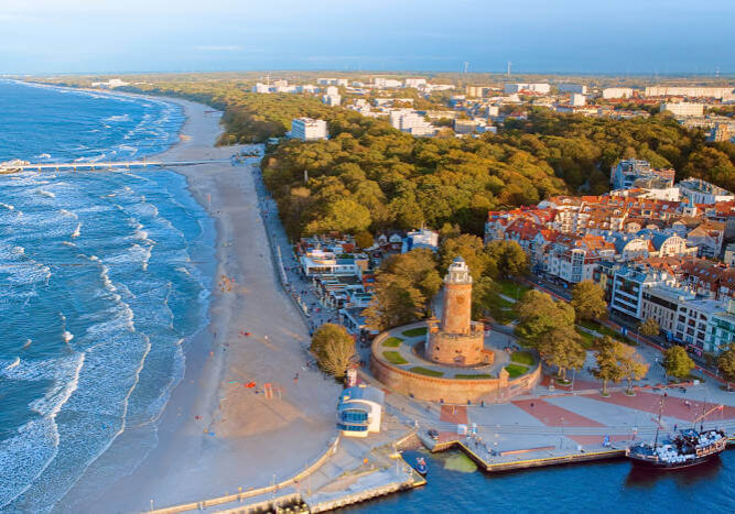 Diese Luftaufnahme konzentriert sich auf den berühmten Leuchtturm von Kołobrzeg und den florierenden Hafen darunter.