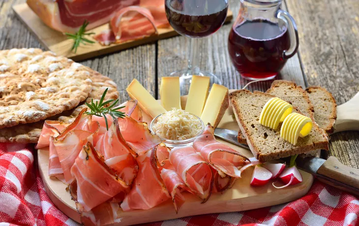 Südtiroler Bauernspeck mit Kren und reifem Bergkäse, dazu Landbrot sowie Rotwein