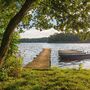 Ein Steg und Boote am See.