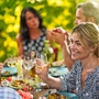 Gruppe Freunde, die um einen Tisch auf einer Terrasse zu Mittag essen