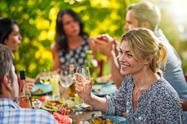 Gruppe Freunde, die um einen Tisch auf einer Terrasse zu Mittag essen